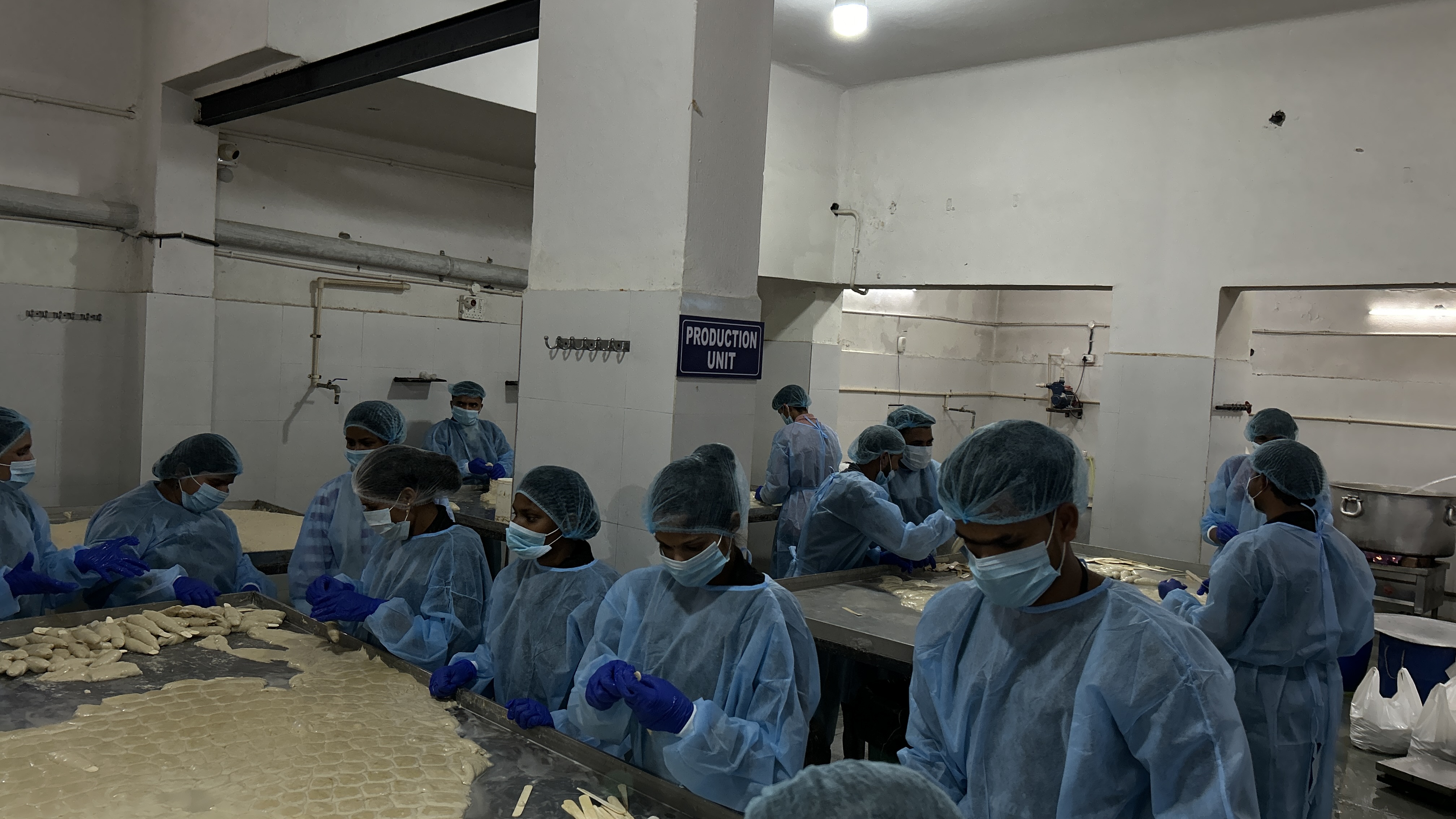 Person holding four potatoes. Potatoes in the background.
